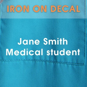May include: Iron-on decal with the text "IRON ON DECAL" in orange letters on a light blue background. The decal also has the text "Jane Smith Medical student" in white letters.