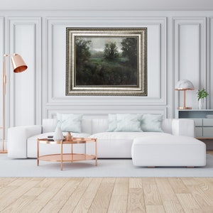 Puede incluir: Un sof&aacute; seccional blanco con almohadas de color azul claro se encuentra frente a una pintura de paisaje enmarcada. Una mesa de caf&eacute; de cobre con dos niveles se encuentra frente al sof&aacute;.