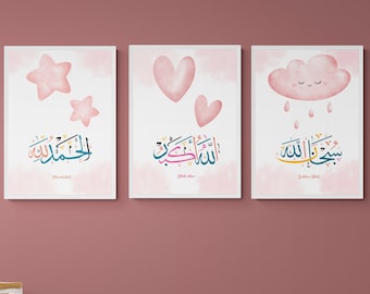 May include: Three pink and white framed prints with Islamic calligraphy and cute illustrations. The first print features a pink star and the Arabic text "SubhanAllah". The second print features a pink heart and the Arabic text "Alhamdulillah". The third print features a pink cloud with a smiling face and the Arabic text "MashaAllah".