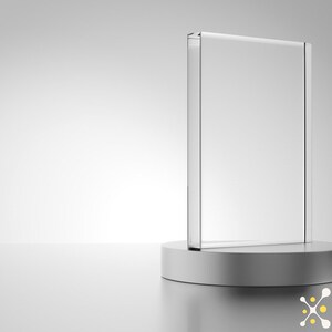 Puede incluir: Una placa de vidrio transparente sobre un pedestal plateado. La placa est&aacute; en blanco y lista para ser personalizada.