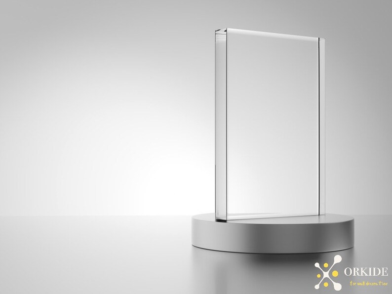Puede incluir: Una placa de vidrio transparente sobre un pedestal plateado. La placa est&aacute; en blanco y lista para ser personalizada.