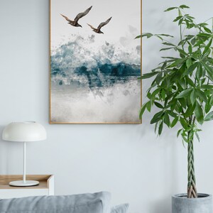 May include: A watercolour painting of two birds flying over a blue and grey ocean with white splashes of paint.