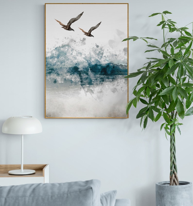 May include: A watercolour painting of two birds flying over a blue and grey ocean with white splashes of paint.