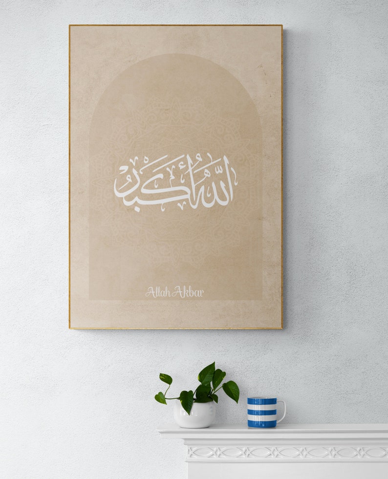 Puede incluir: Una impresi&oacute;n en lienzo beige con un dise&ntilde;o de caligraf&iacute;a &aacute;rabe blanca en forma de arco. El texto dice "Allah Akbar".