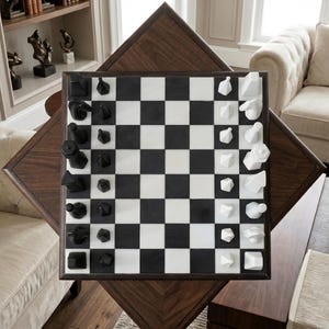 May include: A luxury chess set featuring a black and white chequered board and geometric black and white chess pieces. The board sits on a dark wood table with a diamond-shaped base. The chess set is in a well-lit room.