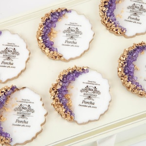 Puede incluir: Seis galletas redondas blancas decoradas con glaseado morado y dorado. Cada galleta tiene un dise&ntilde;o dorado con el texto "50 cumplea&ntilde;os Porcha 4 de diciembre de 2023".