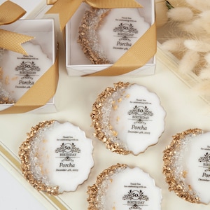 Puede incluir: Cinco galletas redondas blancas decoradas con purpurina dorada y copos de oro comestibles. Cada galleta tiene un dise&ntilde;o en blanco y negro con el texto "Gracias por celebrar con nosotros. 50 cumplea&ntilde;os Porcha 4 de diciembre de 2023".
