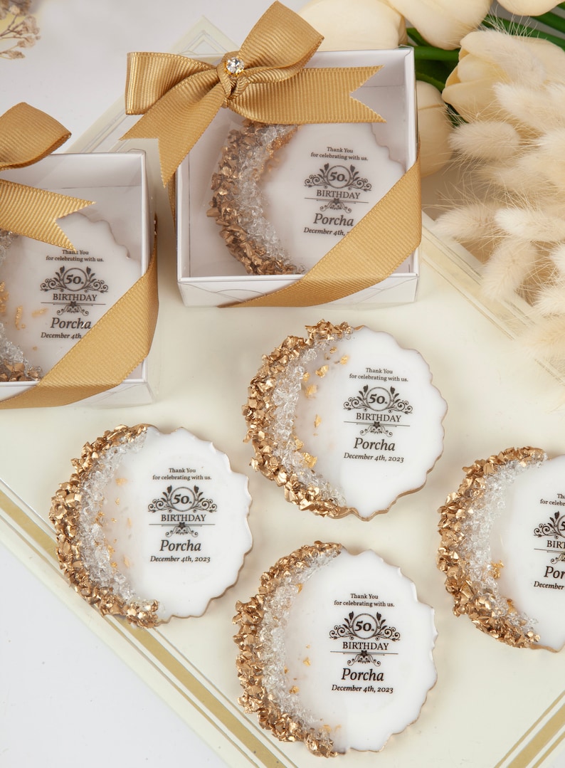 Puede incluir: Cinco galletas redondas blancas decoradas con purpurina dorada y copos de oro comestibles. Cada galleta tiene un dise&ntilde;o en blanco y negro con el texto "Gracias por celebrar con nosotros. 50 cumplea&ntilde;os Porcha 4 de diciembre de 2023".