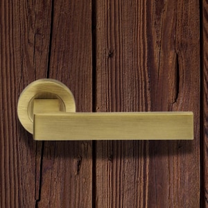 brass Sasso Door Lever On Round Rose. plain straight square edge handle . minimalistic lines, solid brass