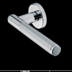 Könnte beinhalten: Ein verchromter Türgriff mit einem strukturierten, rautenförmigen Muster auf dem Hebel. Der Griff hat eine runde Basis.