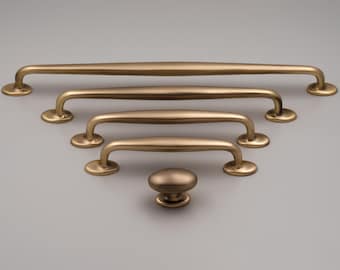 O puxador Ashley para armários, fabricado em latão maciço, apresenta um design clássico e simples, ideal para gavetas, guarda-roupas e cozinhas, tanto em estilos tradicionais quanto modernos.