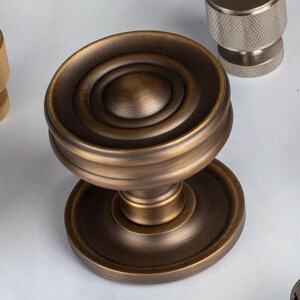 Solid Brass Cupboard Knob features a concave ringed circular face on a circular rose. sophisticated and durable upgrade to your cupboards