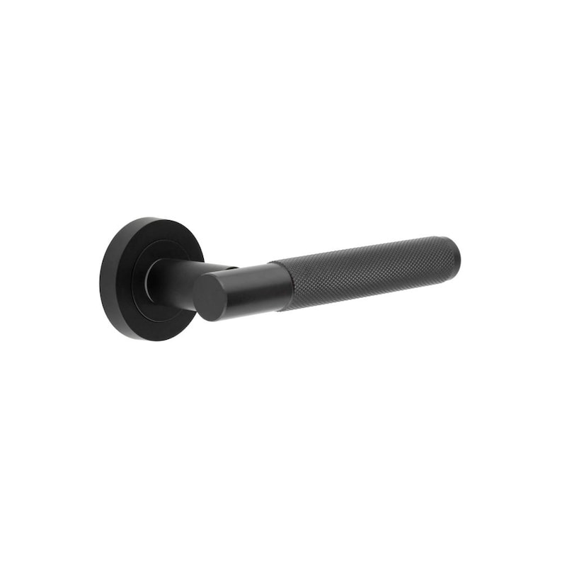 May include: A black door handle with a textured grip and a circular backplate. The handle has a cylindrical shape and is made of metal. The design is modern and minimalist, suitable for interior doors.