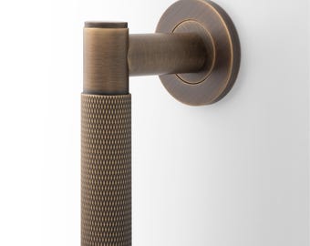 Klamka do drzwi z litego mosiądzu, dostępna w wersji radełkowanej lub żłobkowanej, pasująca do drzwi tyłem do siebie. Zaprojektowana z myślą o estetyce i trwałości.