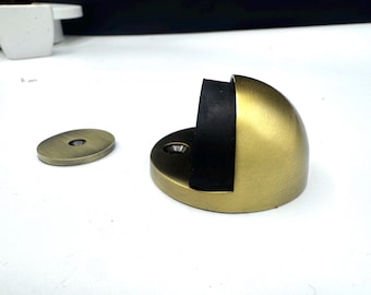Op de vloer gemonteerde deurstopper met massief messing schild, met magnetische openhoudfunctie en rubberen bumper om je deur te beschermen en open te houden bij contact