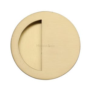 Peut inclure: Une poignée de porte de poche ronde de couleur laiton avec un renfoncement incurvé d'un côté. Le texte "Heritage Brass" est imprimé au centre. La quincaillerie a une finition lisse et mate et est conçue pour une installation encastrée.
