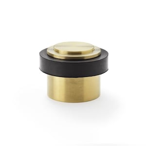 May include: A gold doorstop with a black rubber base. The doorstop has a round top and a cylindrical base.