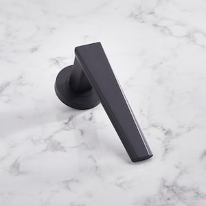 Op de afbeelding: Een zwarte deurknop met een modern, hoekig ontwerp. De knop is gemaakt van metaal en heeft een matte afwerking.