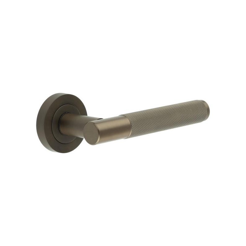 May include: A bronze-toned door handle with a textured grip. The handle features a circular base, a cylindrical neck, and a textured, cylindrical grip. The design is modern and minimalist, suitable for interior doors.