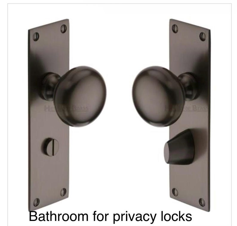 Peut inclure: Deux poign&eacute;es de porte en bronze fonc&eacute; avec plaques arri&egrave;re rectangulaires. Chaque plaque comporte quatre trous de vis. Le texte "Bathroom for privacy locks" est au bas de l'image. Une poign&eacute;e a un verrou d'intimit&eacute;.