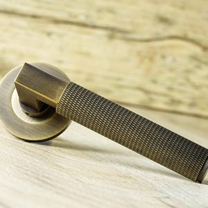 Questa lussuosa coppia di maniglie per porte Hurricane Knurled su rosetta nascosta, maniglia a leva in ottone massiccio di alta gamma e peso elevato, stile contemporaneo,