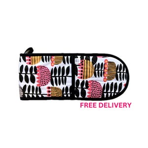 May include: Black and white oven mitt with a floral pattern in pink, yellow, and black. The mitt is quilted and has a loop for hanging.