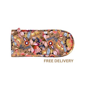 May include: A brown oven mitt with a colourful floral pattern. The mitt is made of fabric and has a loop for hanging.