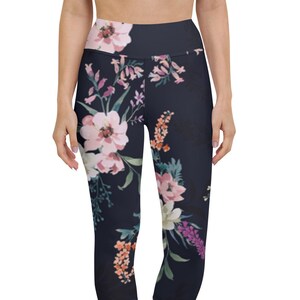 May include: Black capri leggings with a floral print featuring pink, orange, and purple flowers. The leggings have a high waist.