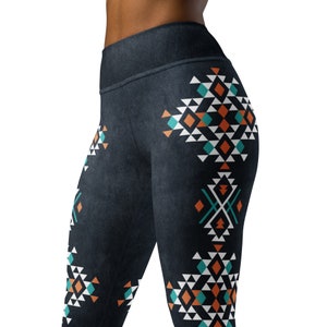 May include: Black leggings with a geometric pattern in shades of orange, teal, and white. The pattern is on the sides of the leggings and features triangles, diamonds, and lines.