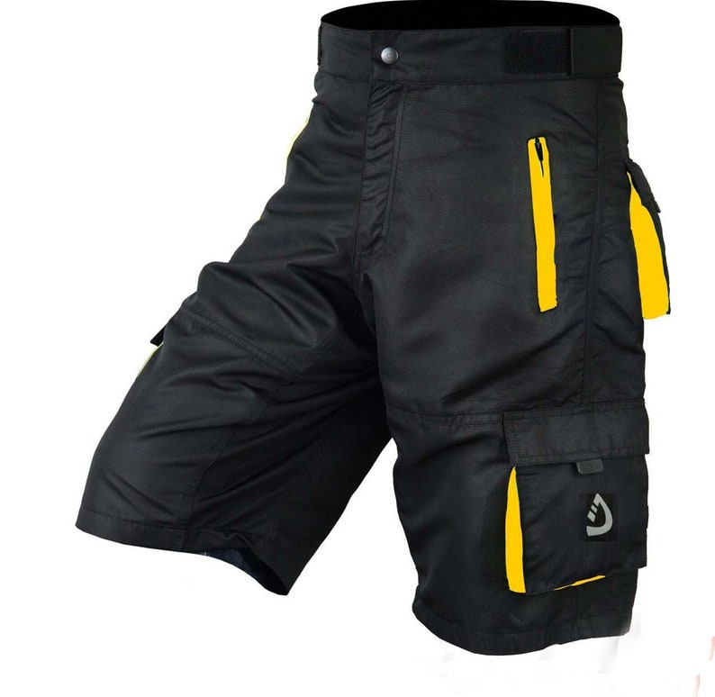 May include: Black cargo shorts with yellow accents and a zippered pocket. The shorts have multiple pockets and a logo on the right leg.