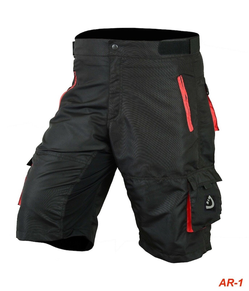 May include: Black cycling shorts with red accents and multiple pockets. The shorts have a zippered pocket on the right leg and a large cargo pocket on the left leg.