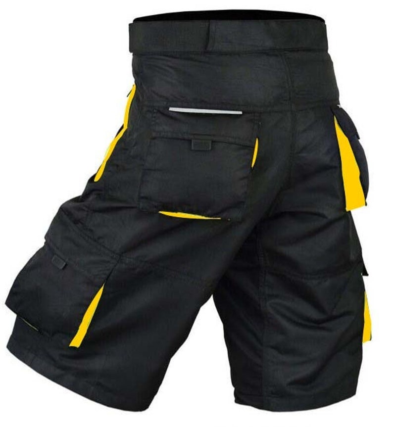 May include: Black work shorts with yellow trim and multiple pockets. The shorts have a belt loop and a zipper fly.