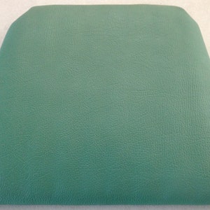 Peut inclure: Un coussin de siège rectangulaire vert texturé.