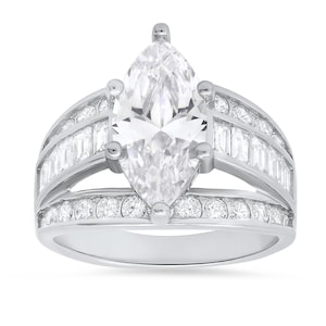 May include: A silver ring with a large marquise-shaped diamond surrounded by smaller diamonds. The band is wide and features a row of baguette-shaped diamonds on each side.