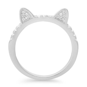 May include: A silver ring with a cat ear design. The ears are set with small clear stones.