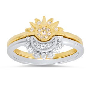 May include: A two-piece ring set featuring a gold sun and a silver crescent moon, both adorned with sparkling cubic zirconia stones.