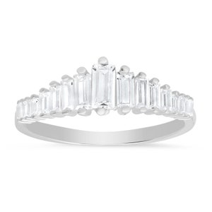 May include: A silver ring with a row of baguette-shaped clear stones set in a crown shape.