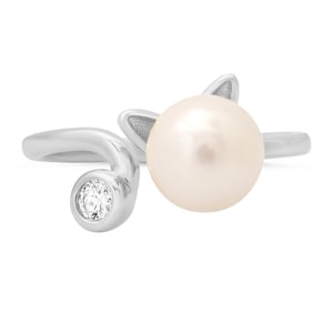 May include: A silver ring with a white pearl and a small clear stone. The ring is designed in the shape of a cat's head with the pearl as the head and the stone as the eye.
