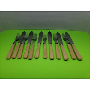 May include: A set of twelve silver-toned butter knives with ivory-colored handles.