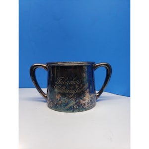 May include: A silver sugar bowl with two handles. The bowl has an inscription that reads "Falbocher's Caterway Co."