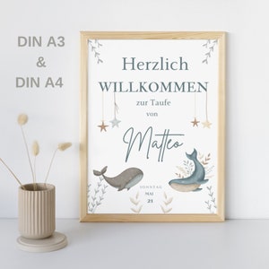 Puede incluir: Una impresi&oacute;n enmarcada blanca con un dise&ntilde;o de ballena azul y marr&oacute;n. El texto dice "Herzlich Willkommen zur Taufe von Matteo Sonntag Mai 21".