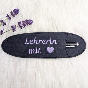 Könnte beinhalten: Ein schwarzer Kork-Stift-Halter mit einem lila gestickten Herzen und dem Text "Lehrerin mit".