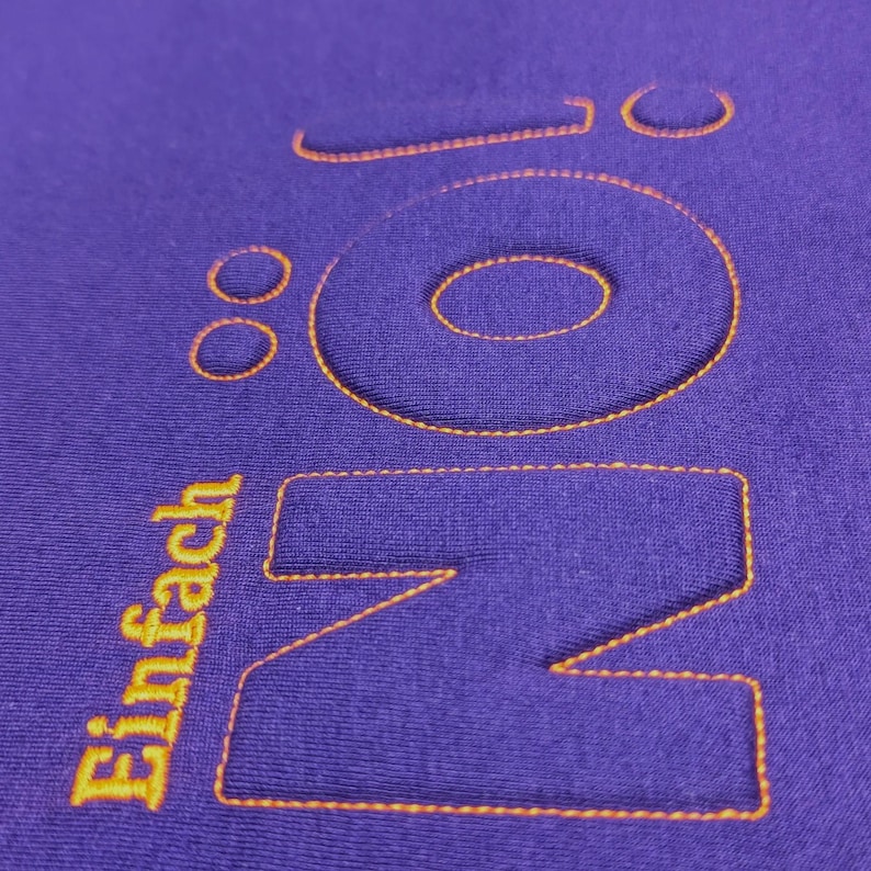 Puede incluir: Sudadera morada con la palabra "NO" en letras grandes bordadas en naranja. La palabra "Einfach" est&aacute; bordada en naranja debajo de la "NO".