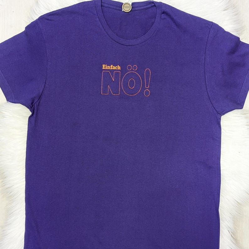 Puede incluir: Camiseta morada con el texto "Einfach NO!" en naranja y rojo.
