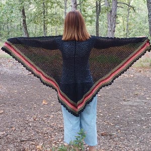 May include: A black crochet shawl with a multi-colored border. The border features shades of green, pink, and red.