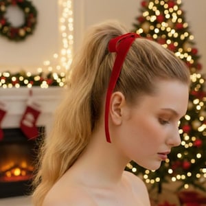a velvet hair bow made with thin velvet ribbon in a long tail design attached to a french barrette clip, shown as a long tail hair bow suitable as a hair bow for women and hair bows for girls. the shape works as a ribbon hair bow or hairpin bow clip, styled like a ponytail holder bow or long ribbon bow. ideal as a christmas hair bow and fits gifting needs such as gift for her or gift for girl.