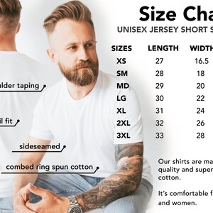 Op de afbeelding: Wit unisex jersey T-shirt met korte mouwen en een maattabel. De tabel toont maten XS tot 3XL, met lengtes van 68,5 cm tot 83,8 cm en breedtes van 41,9 cm tot 71,1 cm. Kenmerken zijn schoudertaping, retail pasvorm en zijnaden.