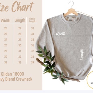 K&ouml;nnte beinhalten: Ein hellgraues Gildan 18000 Heavy Blend Crewneck Sweatshirt h&auml;ngt an einem Holzb&uuml;gel. Das Bild enth&auml;lt eine Gr&ouml;&szlig;entabelle mit Ma&szlig;en in cm f&uuml;r Breite, L&auml;nge und &Auml;rmell&auml;nge. Der Text "Size Chart" steht oben.