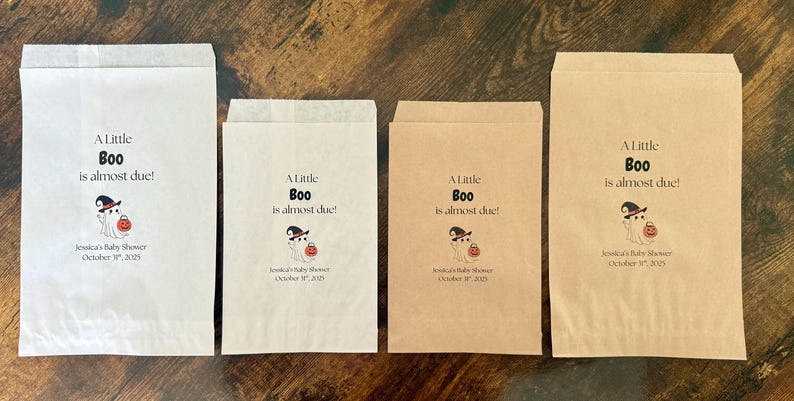 K&ouml;nnte beinhalten: Vier Papiert&uuml;ten, zwei wei&szlig;e und zwei braune, mit dem Text "A Little Boo is almost due!" und einer Geisterillustration. Die T&uuml;ten sind f&uuml;r eine Babyparty, mit dem Datum unter der Illustration.