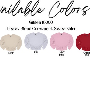 May include: Image showcasing a selection of Gildan 18000 Heavy Blend Crewneck Sweatshirts in various colors. Colors include white, black, sand, ash, light pink, cherry red, and forest green. The text "Available Colors" is at the top.